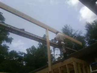 Carpenter setting a ridge beam over a new addition frame — Ice Dam Removal by Roofing Brothers in La Prairie