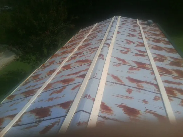Rusted metal roof panels with new wood purlins before replacement — Storm Damage Roof Repair in La Prairie by Roofing Brothers
