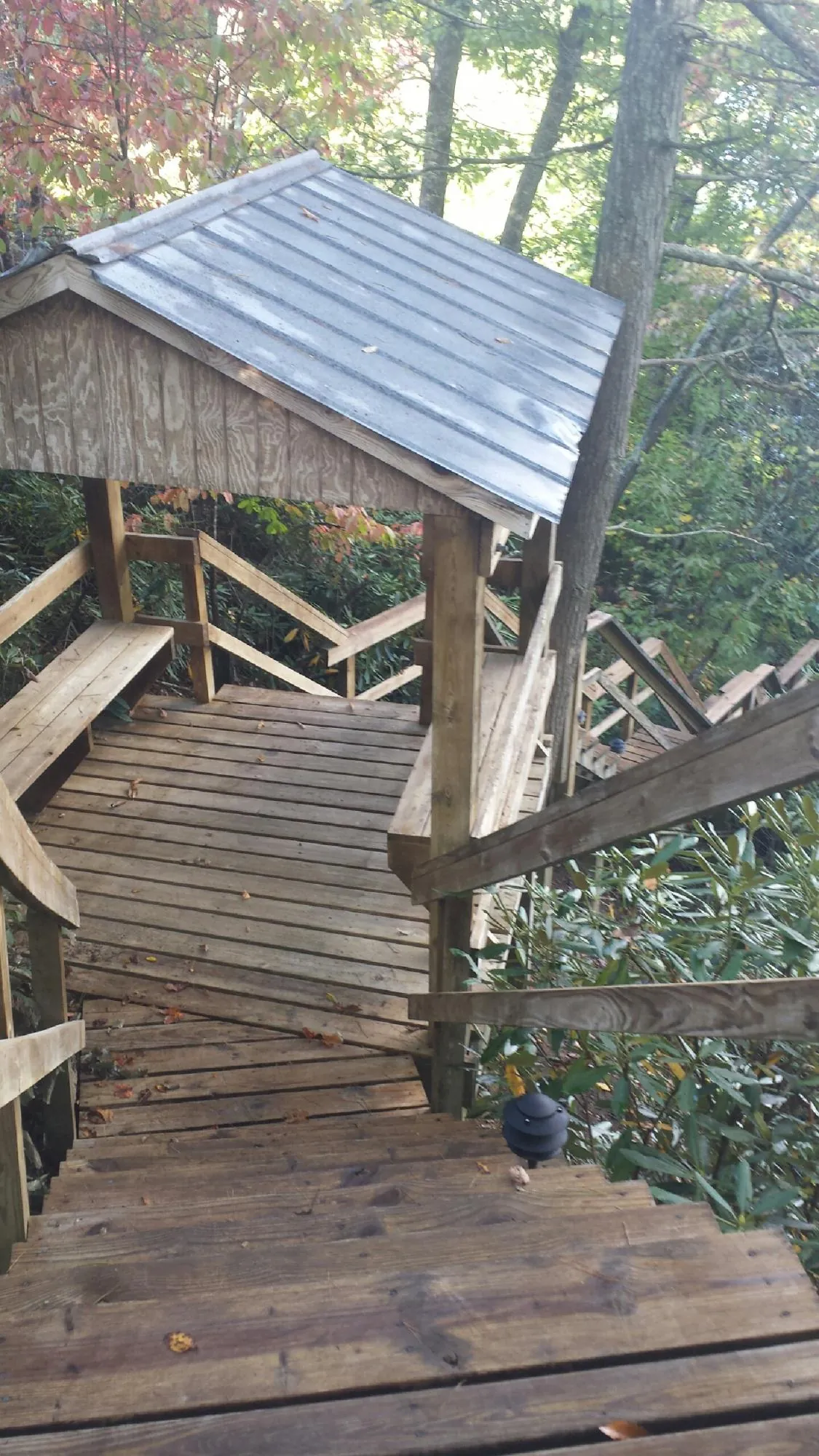 Metal roofed shelter over wooden steps on a wooded walkway — Skylight Repair & Installation work by our crew in La Prairie