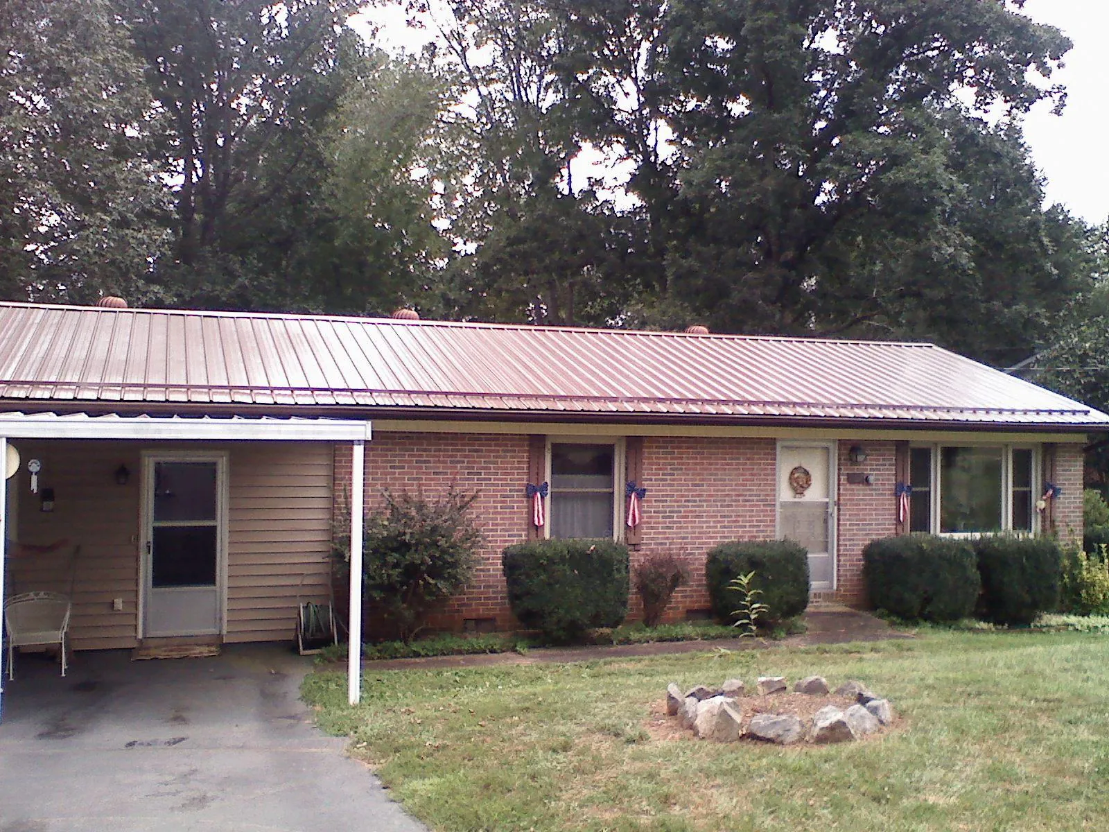 Bronze metal roof and carport on a brick ranch home — Roof Repair work by our crew in La Prairie